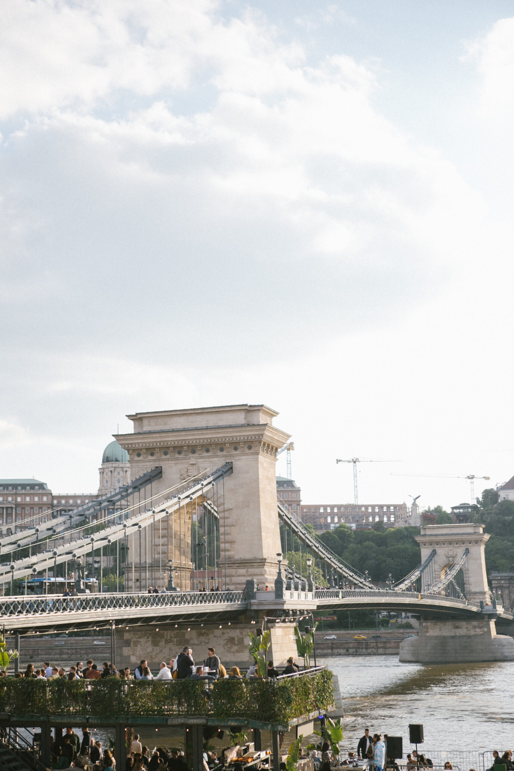 Romantic couple standing near the Chain Bridge in Budapest during an engagement session at sunset