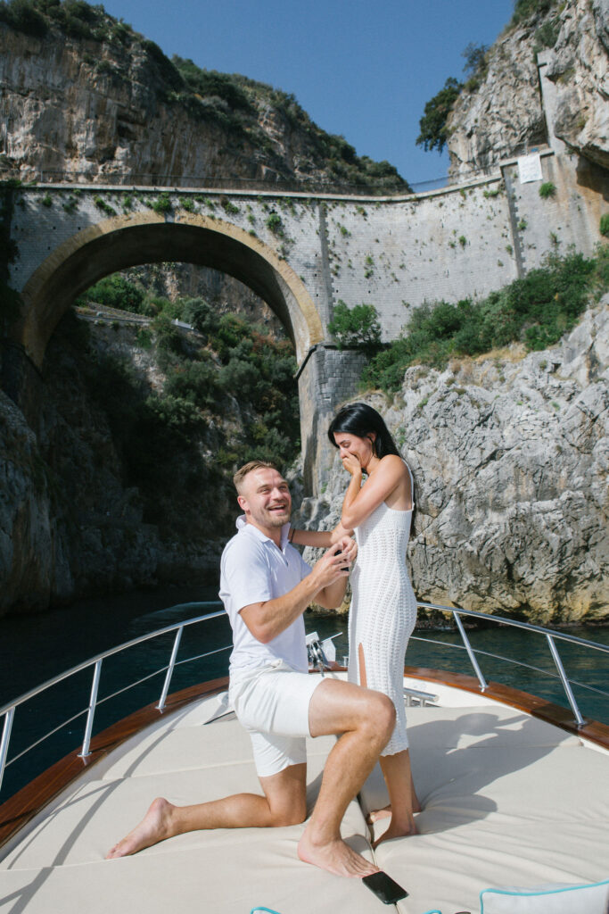 
Man proposing on a luxury boat near Fiordo di Furore, Amalfi Coast – surprise engagement moment with emotional reaction