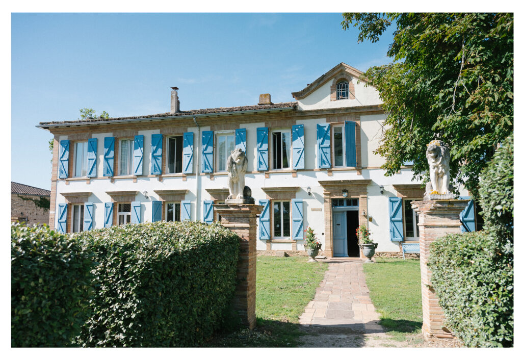 Guests cheering as couple walks down the aisle at French countryside wedding.